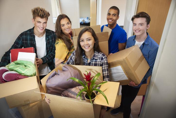 A group of five university students move into their dorm and start to unpack boxes.